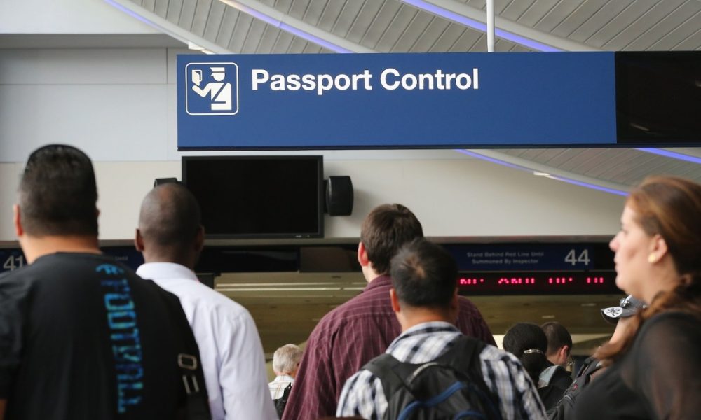 International travelers wait to have their passports checked at O