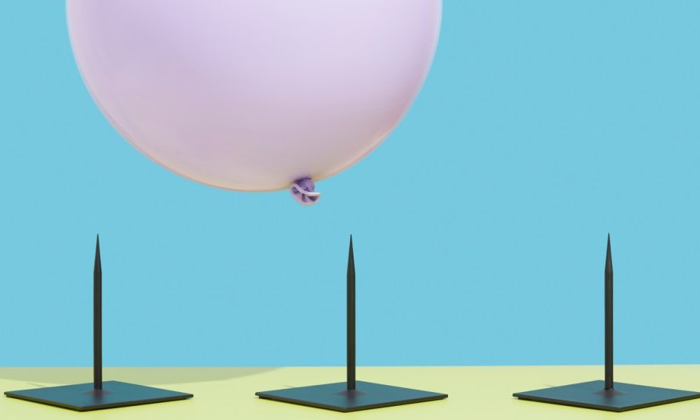 Image of a pink balloon hovering over three spikes to represent risk.