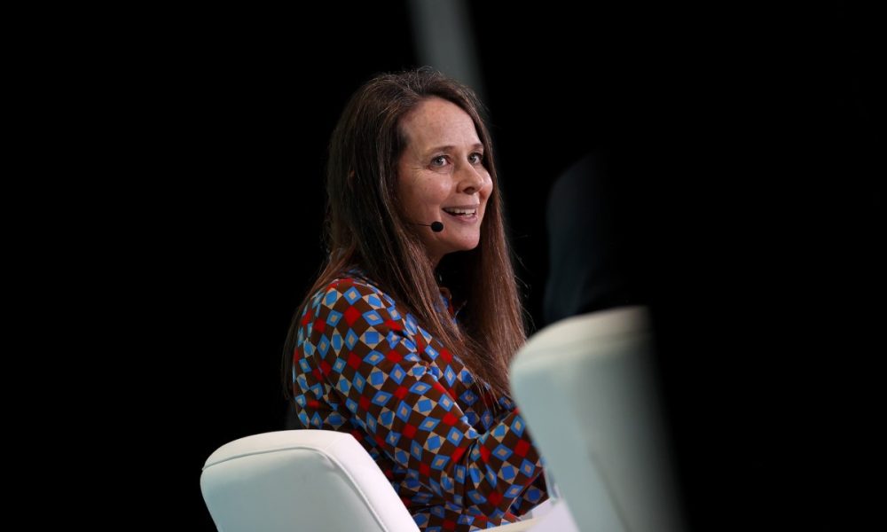 a photo of CISA director Jen Easterly speaking on stage against a dark background