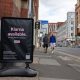 Members of the public pass by a floor advertisement for tech firm Klarna.